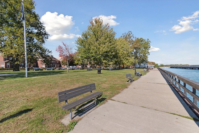 surrounding community with a water view and a yard