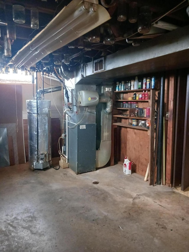 unfinished below grade area with water heater, visible vents, and heating unit