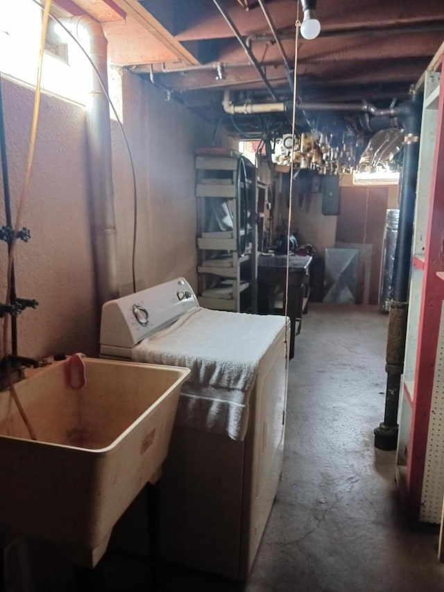 clothes washing area with washer / dryer, laundry area, electric panel, and a sink