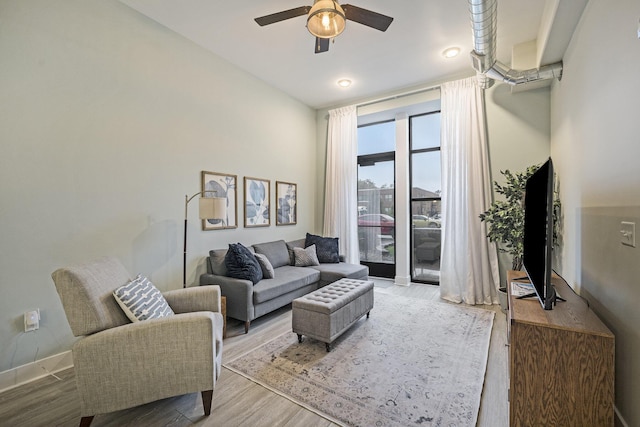 living room with ceiling fan and light hardwood / wood-style floors