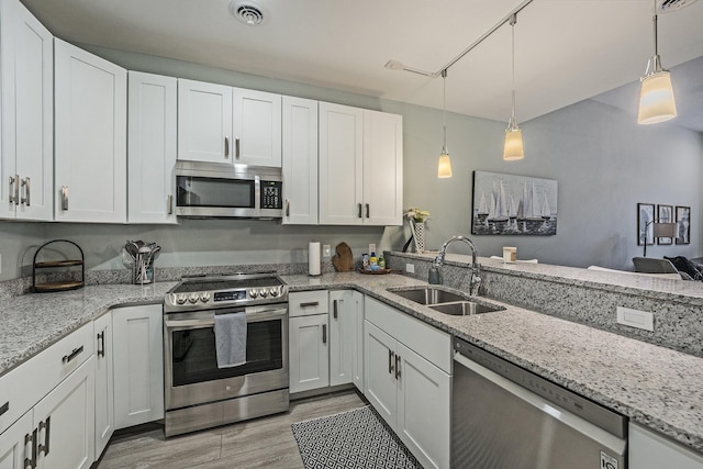 kitchen featuring white cabinetry, stainless steel appliances, sink, and pendant lighting