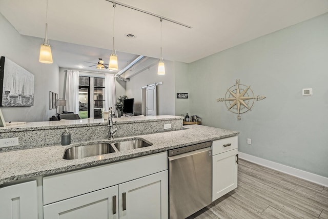 kitchen with dishwasher, sink, white cabinets, and light stone counters