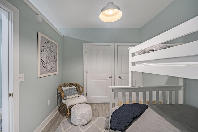 bedroom with hardwood / wood-style flooring and a crib