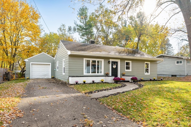 view of front of property with a garage, an outdoor structure, and a front yard