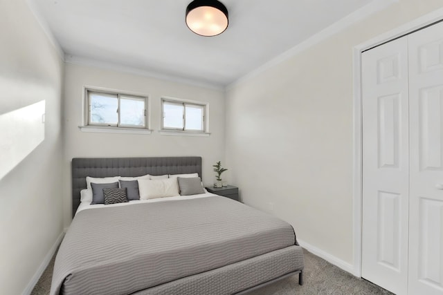 carpeted bedroom with ornamental molding and a closet