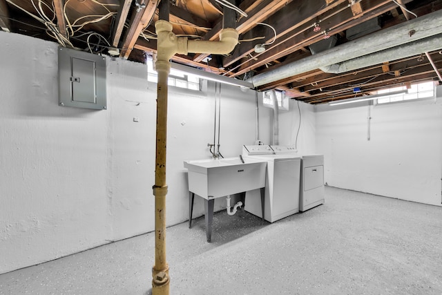 basement with washing machine and dryer, sink, and electric panel