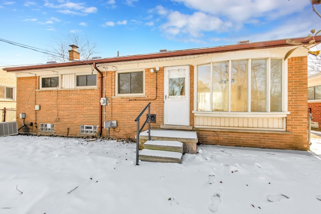 snow covered property with central AC