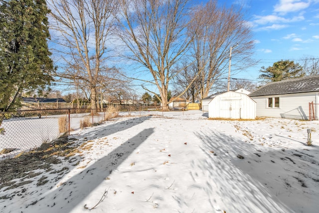 yard covered in snow with a storage unit