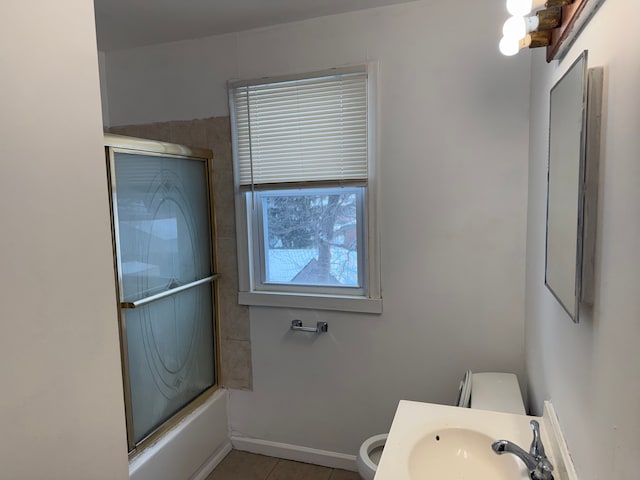 full bathroom with tile patterned flooring, sink, shower / bath combination with glass door, and toilet