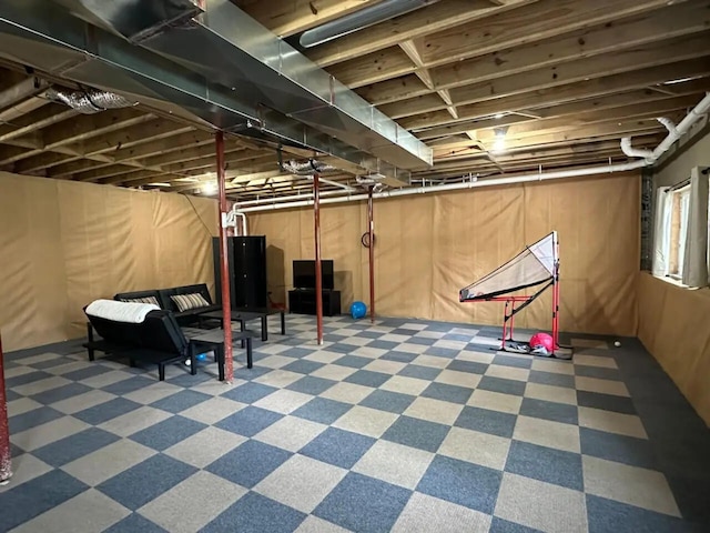 basement featuring water heater and wood walls