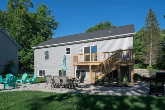 back of property featuring a deck, a patio, and a lawn