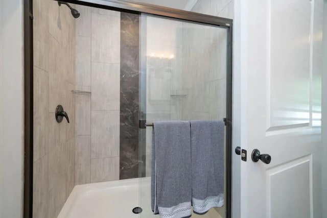 bathroom with a shower with door