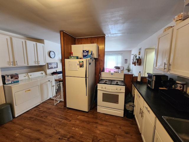 kitchen featuring dark wood-type flooring, sink, white appliances, washing machine and dryer, and white cabinets