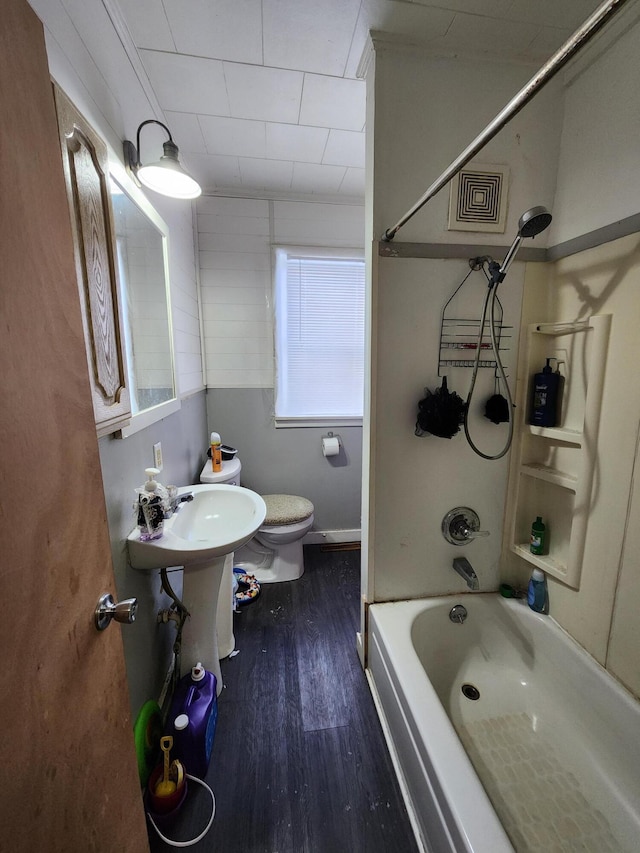 bathroom featuring hardwood / wood-style flooring, tub / shower combination, and toilet