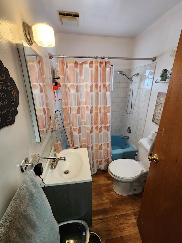 full bathroom with vanity, hardwood / wood-style floors, shower / tub combo with curtain, and toilet