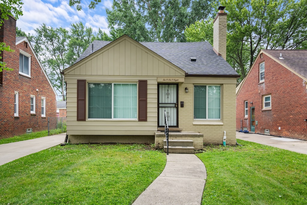 bungalow-style house featuring a front lawn