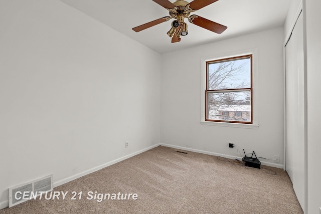 spare room featuring ceiling fan and carpet floors