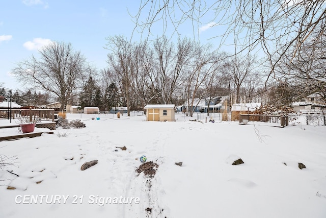 snowy yard featuring a storage unit