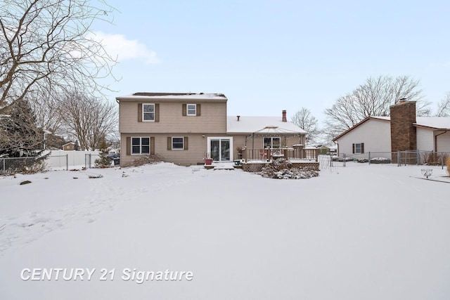 snow covered rear of property with a gazebo and a wooden deck