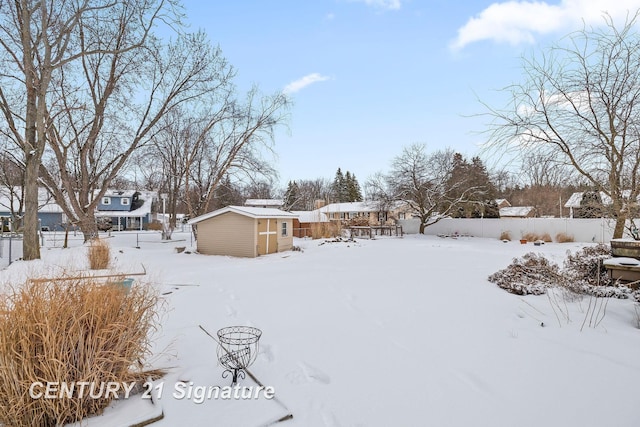 yard covered in snow with a storage shed