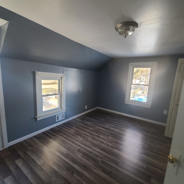 additional living space with lofted ceiling, dark hardwood / wood-style floors, and a wealth of natural light