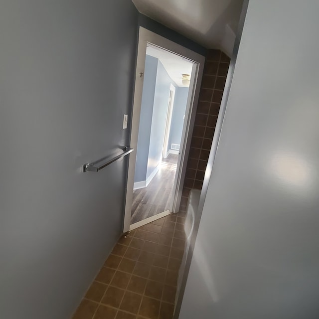 hall featuring dark tile patterned flooring