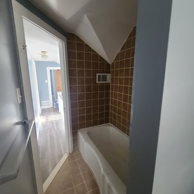 bathroom featuring vaulted ceiling and tile patterned floors