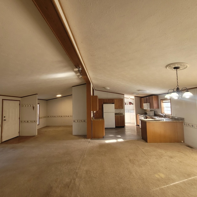 kitchen featuring white appliances, hanging light fixtures, vaulted ceiling, light colored carpet, and kitchen peninsula