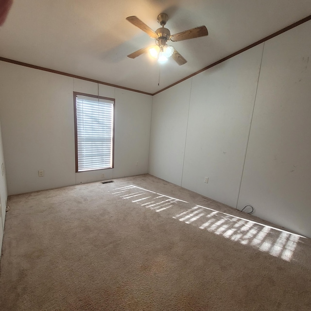 carpeted spare room with ornamental molding and ceiling fan