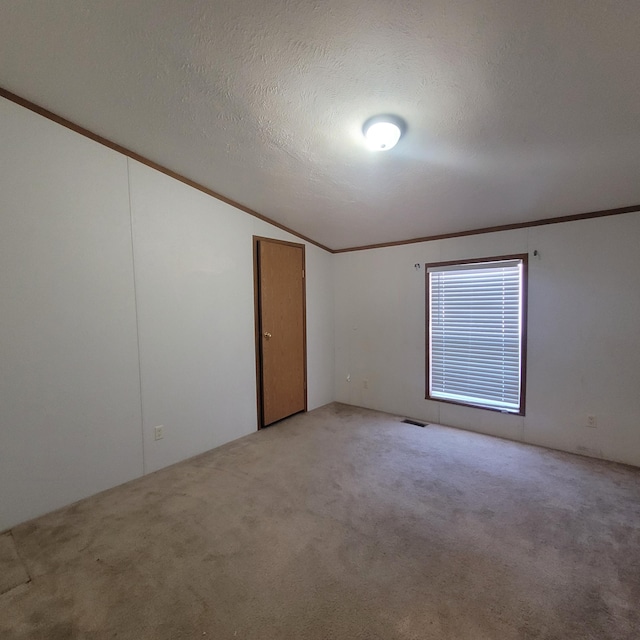 unfurnished room featuring light carpet, crown molding, lofted ceiling, and a textured ceiling