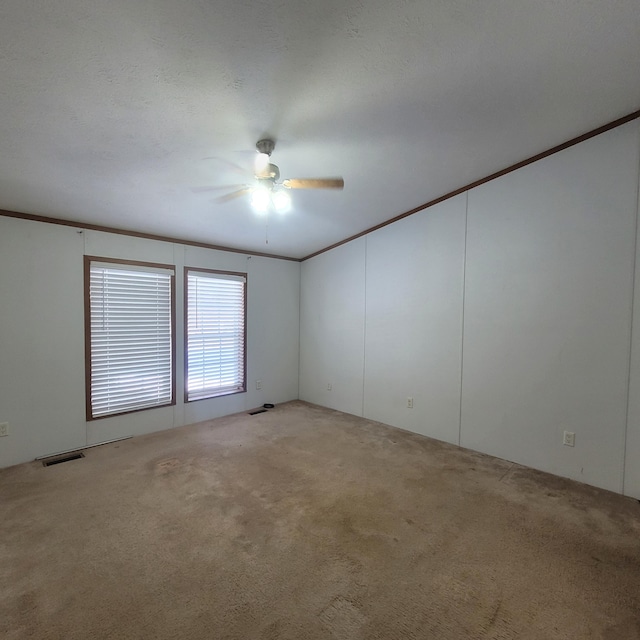 carpeted empty room with ceiling fan and ornamental molding