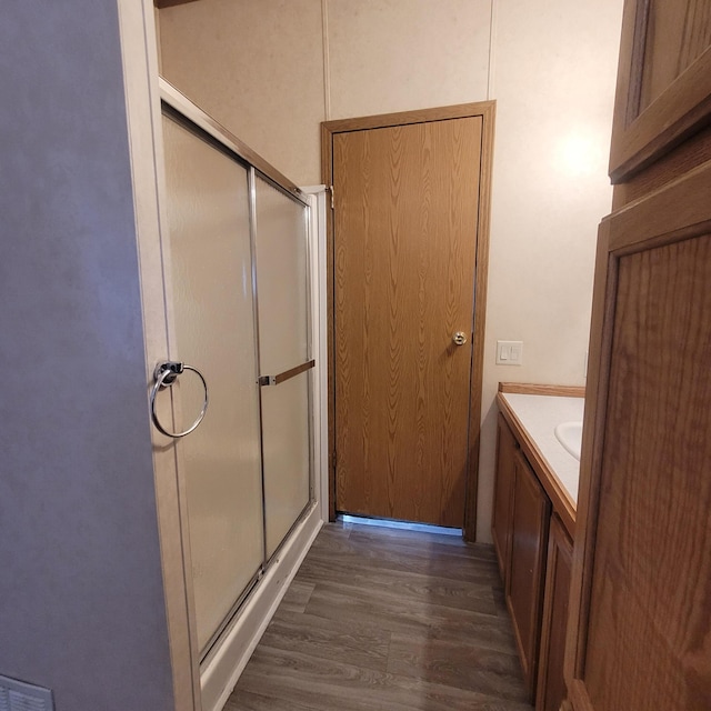 bathroom with vanity, a shower with door, and hardwood / wood-style floors