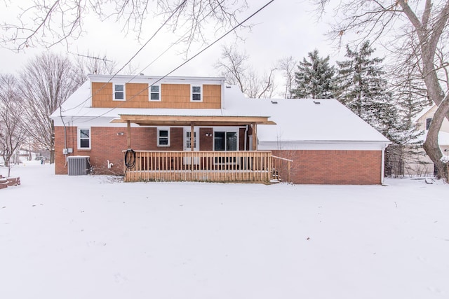 snow covered back of property featuring cooling unit and a porch