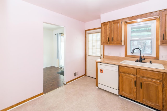 kitchen featuring white dishwasher and sink