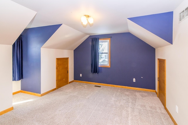 additional living space featuring lofted ceiling and light carpet