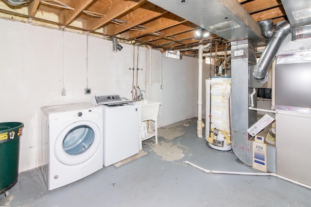 basement featuring heating unit, gas water heater, and washing machine and clothes dryer