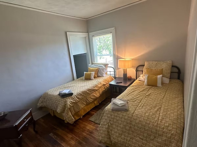 bedroom featuring ornamental molding and dark wood-type flooring