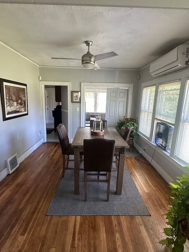 dining area featuring wood-type flooring, a textured ceiling, ceiling fan, and a wall unit AC