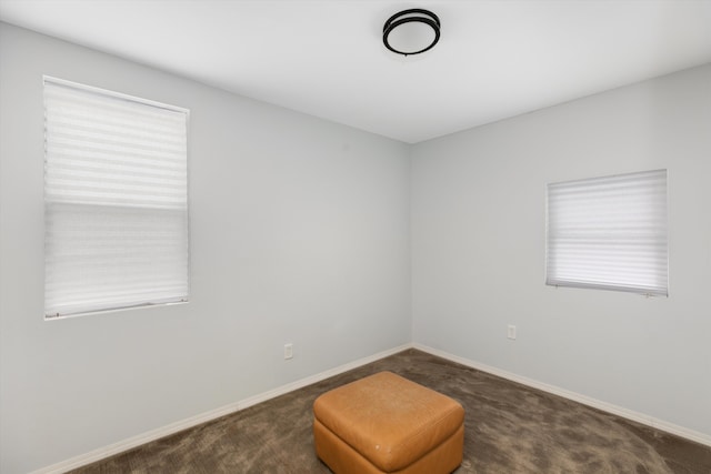 sitting room with a healthy amount of sunlight and dark colored carpet