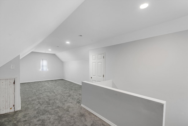 additional living space with lofted ceiling and dark carpet