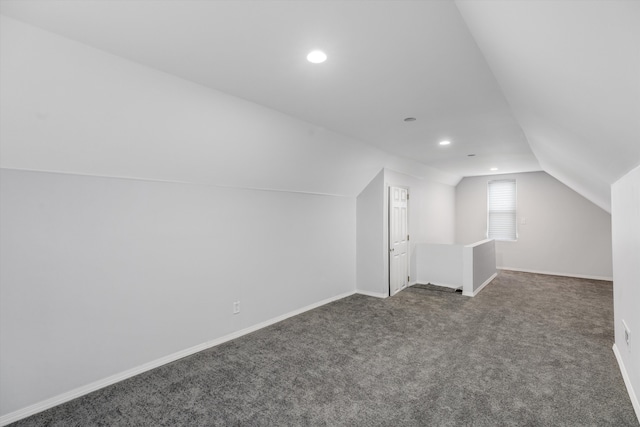 additional living space featuring lofted ceiling and dark carpet