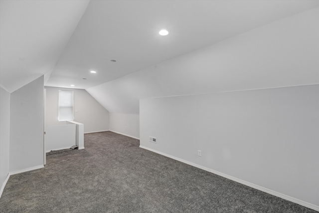 bonus room featuring dark colored carpet and lofted ceiling