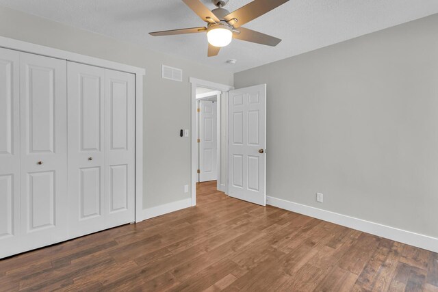 unfurnished bedroom featuring hardwood / wood-style flooring, ceiling fan, and a closet