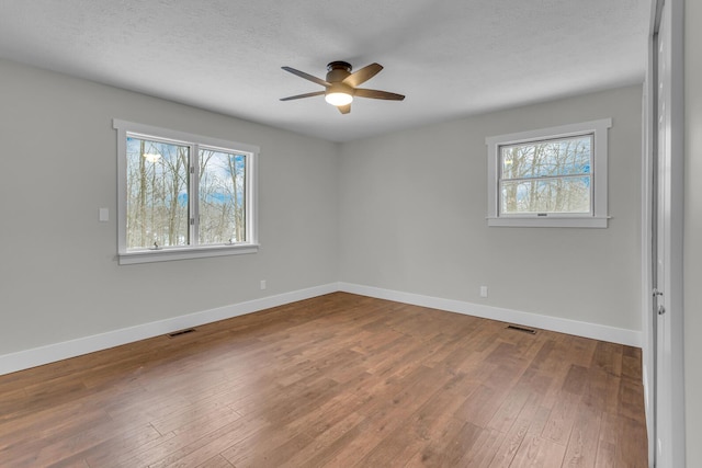 unfurnished room featuring ceiling fan, hardwood / wood-style floors, and a textured ceiling