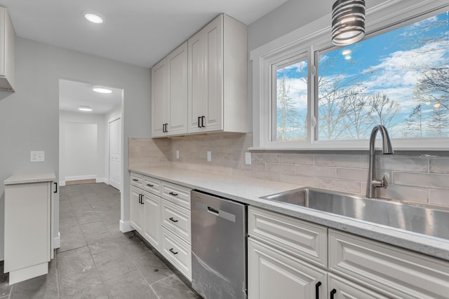 kitchen featuring dishwasher, sink, and white cabinets