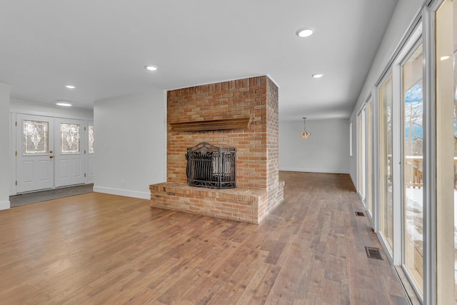 unfurnished living room with a brick fireplace and hardwood / wood-style floors