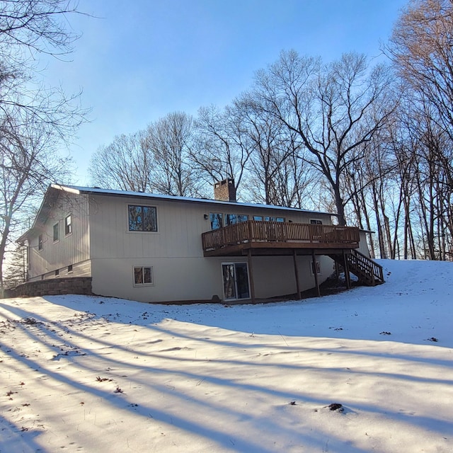 snow covered property with a wooden deck