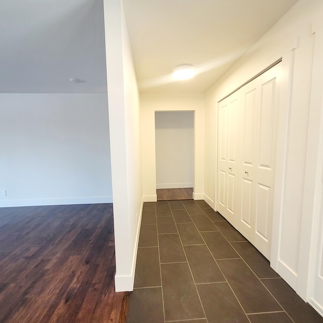 hallway featuring dark tile patterned flooring