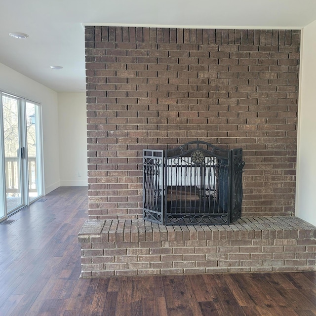 interior details featuring a brick fireplace and hardwood / wood-style flooring