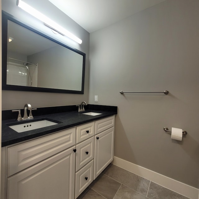 bathroom with tile patterned flooring, vanity, and a shower